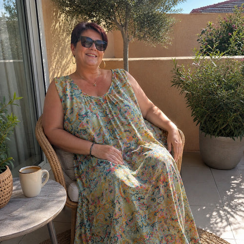 Cliente ravie sur sa terrasse portant une robe grande taille du 50 au 70+, avis client Nos Copines